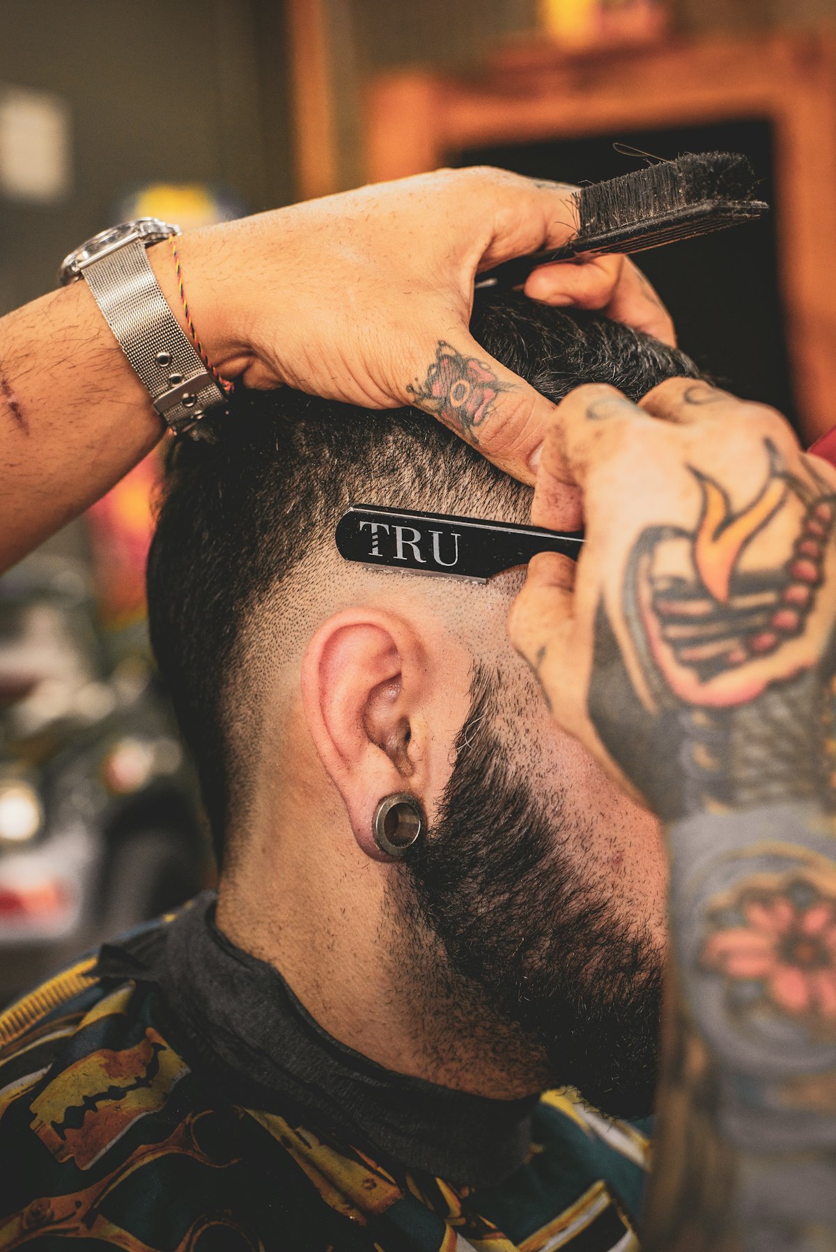 Barbero perfilando un fade con navaja